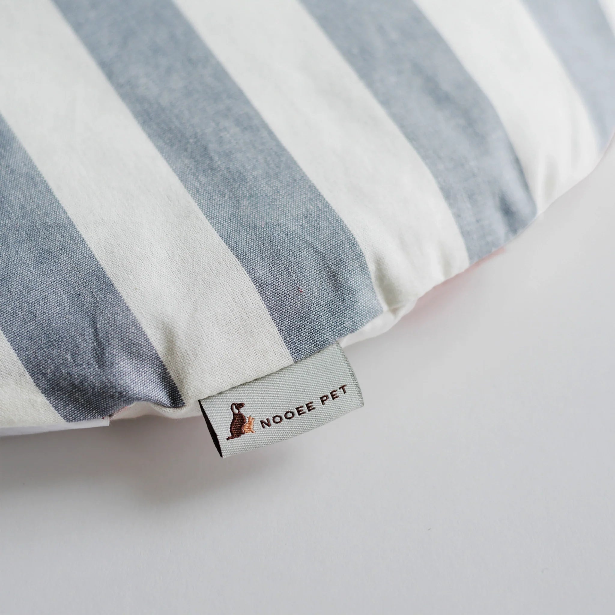 Striped pet bed with a visible brand label on a light background